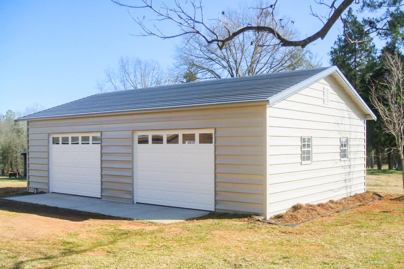 a cream fully enclosed carport garage with white garage doors.