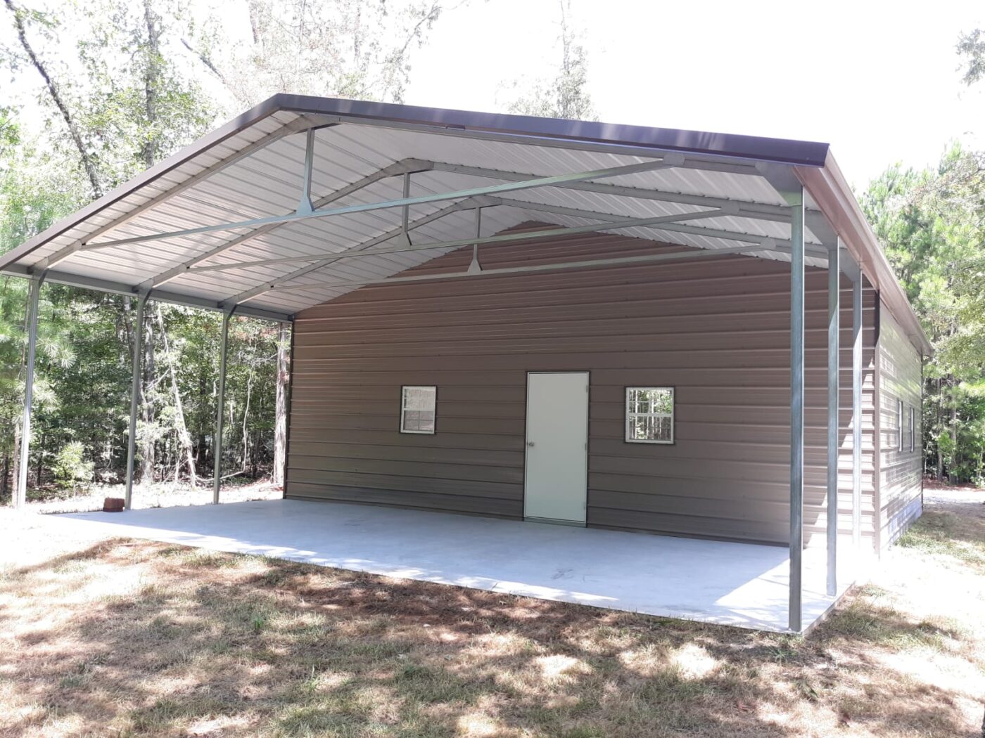 a brown and white carport with storage. includes a white door and white windows