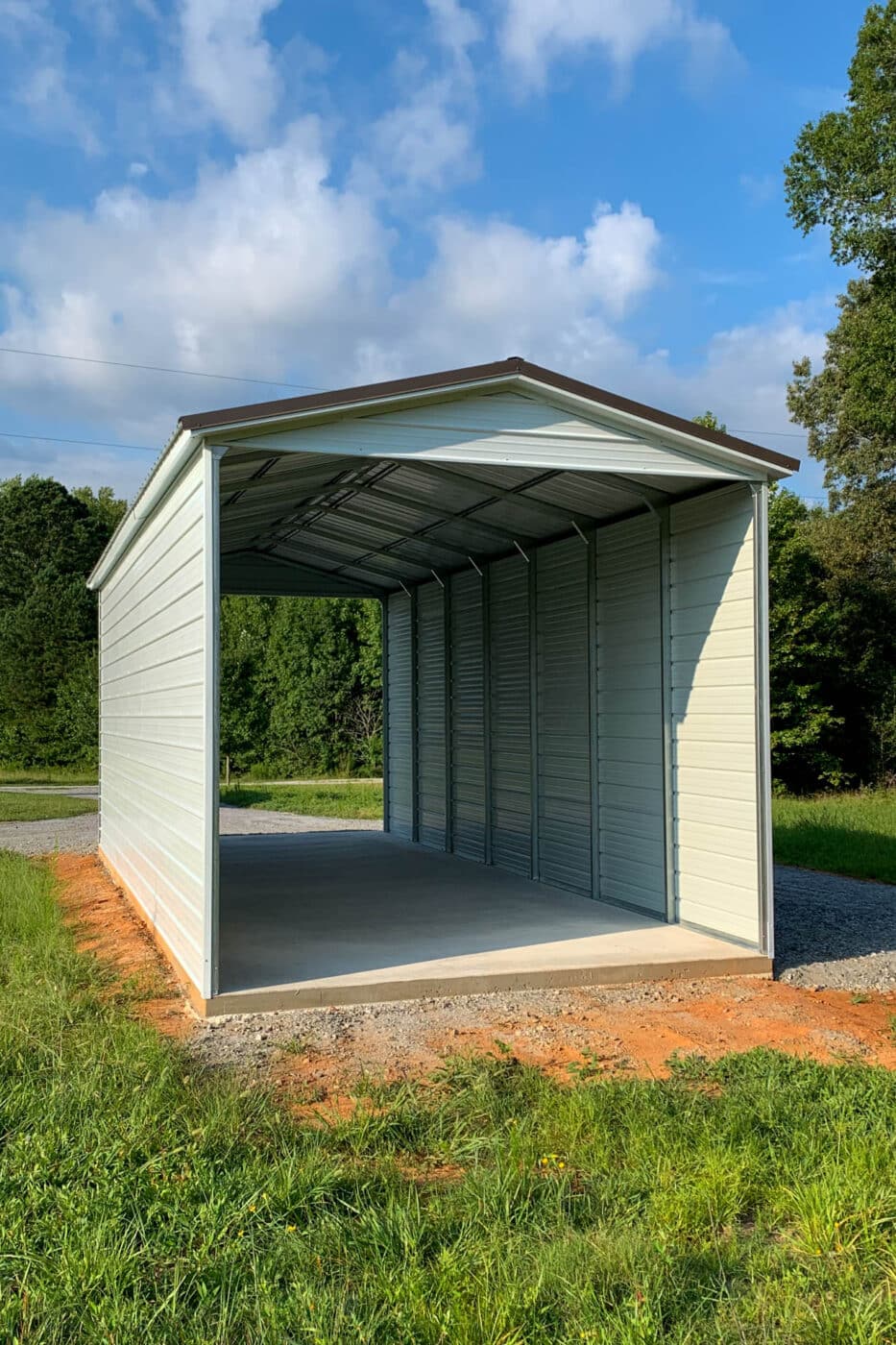 an off white extra tall RV carport cover with a gabled roof with brown roof trim